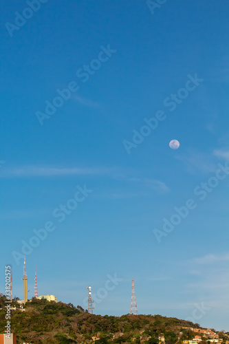 Linda lua branca no céu azul e o Morro da Cruz na cidade de Florianópolis, Santa Catarina, Brasil