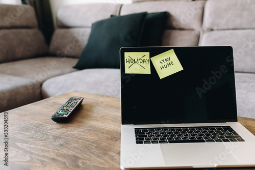 Post it sticky notes on laptop computer at home, stay at home rule and holiday cancelled during travel ban due to coronavirus covid-19 covid 19