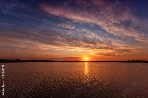 Beautiful sunset on the lake with clouds and reflections on the water