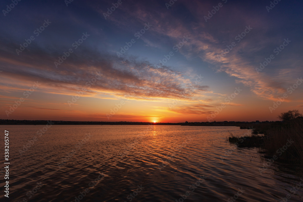 Fototapeta premium Beautiful sunset on the lake with clouds and reflections on the water