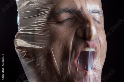 close-up portrait of a plastic bag on the face asphyxiation photo