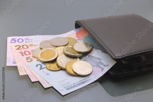 Colombia Money, Currency of Colombia, Pesos, various bills and coins inside a wallet, close-up on dark background. Cash money