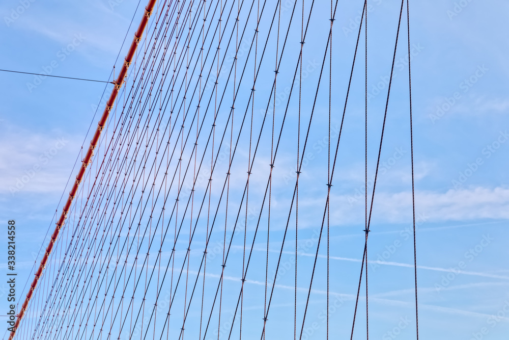 Fototapeta premium Brooklyn Bridge cable net against blue sky, New York