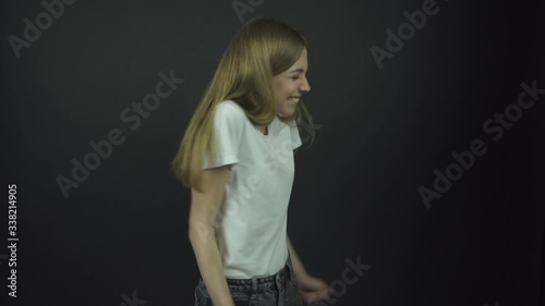 girl in white t-shirt jumps and shakes hands with happiness