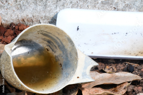 Fotografija plastic bowl abandoned in a vase with stagnant water inside