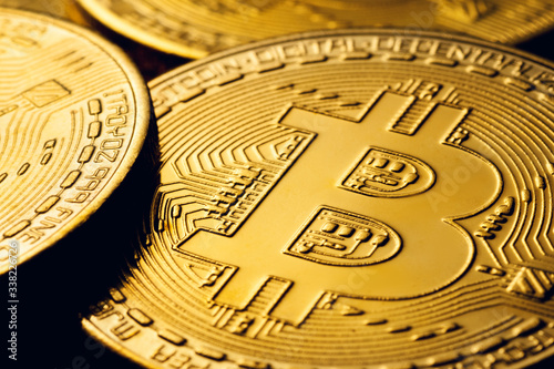 Golden colored bitcoin coins on a black background.