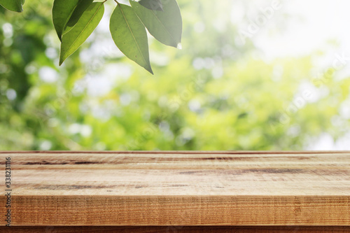 Wooden table and blurred bokeh garden green nature background.