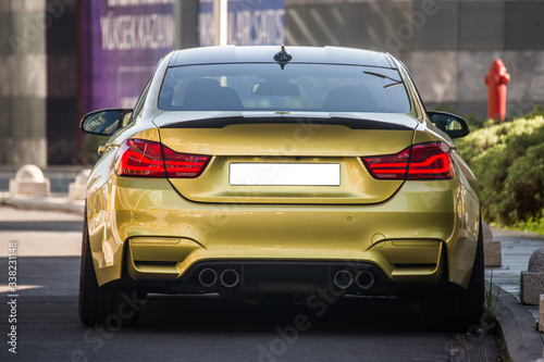 Yellow sport model car with red xenon lights, view from behind