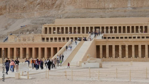 Lots of Tourists Came on an Excursion to the Archaeological Zone in the Vicinity of Luxor. They Can See Architecture of Ancient Egypt. The Temple of Hatshepsut Was Made in a High Cliffs.