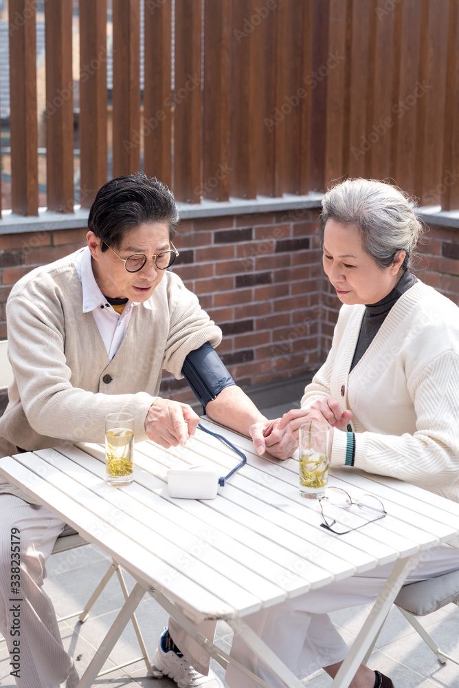 An old Asian couple using a sphygmomanometer An old Asian couple using a sphygmomanometer