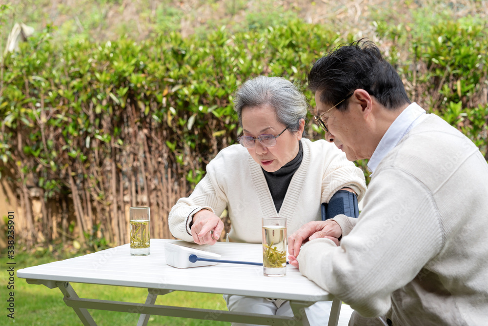 An old Asian couple using a sphygmomanometer An old Asian couple using a sphygmomanometer