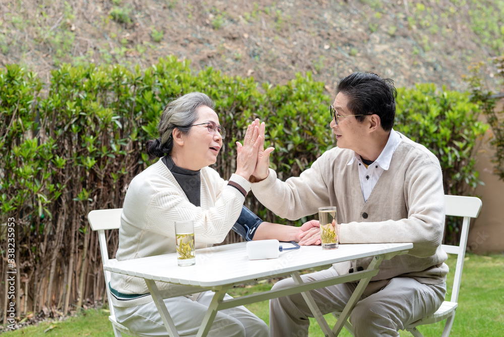 An old Asian couple using a sphygmomanometer