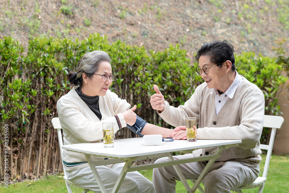 An old Asian couple using a sphygmomanometer An old Asian couple using a sphygmomanometer