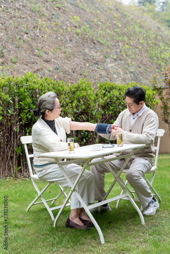 An old Asian couple using a sphygmomanometer © 出 小