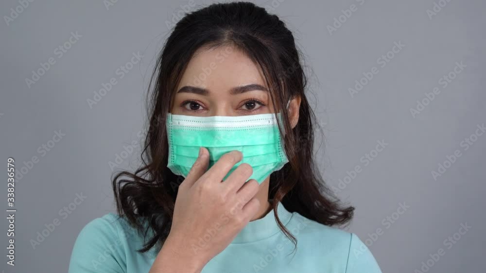 woman removes a medical mask (surgical mask) and smiling woman removes a medical mask (surgical mask) and smiling