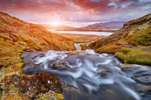 Sheep's Waterfall. Famous tourist landscape. Travel concept background. Dramatic summer sunrise, Iceland, Atlantic Ocean, Europe. Travel postcard. Amazing Sunset. Beautiful Sunrise. Virgin Nature.
