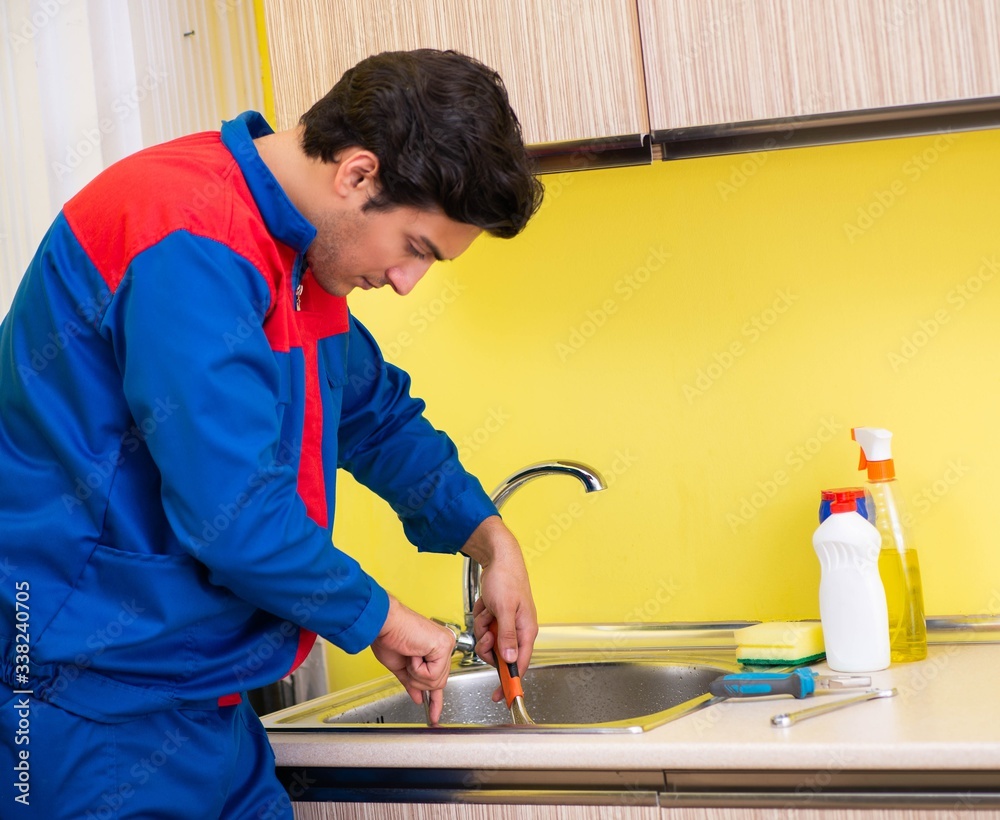 Plumber repairing tap at kitchen Plumber repairing tap at kitchen