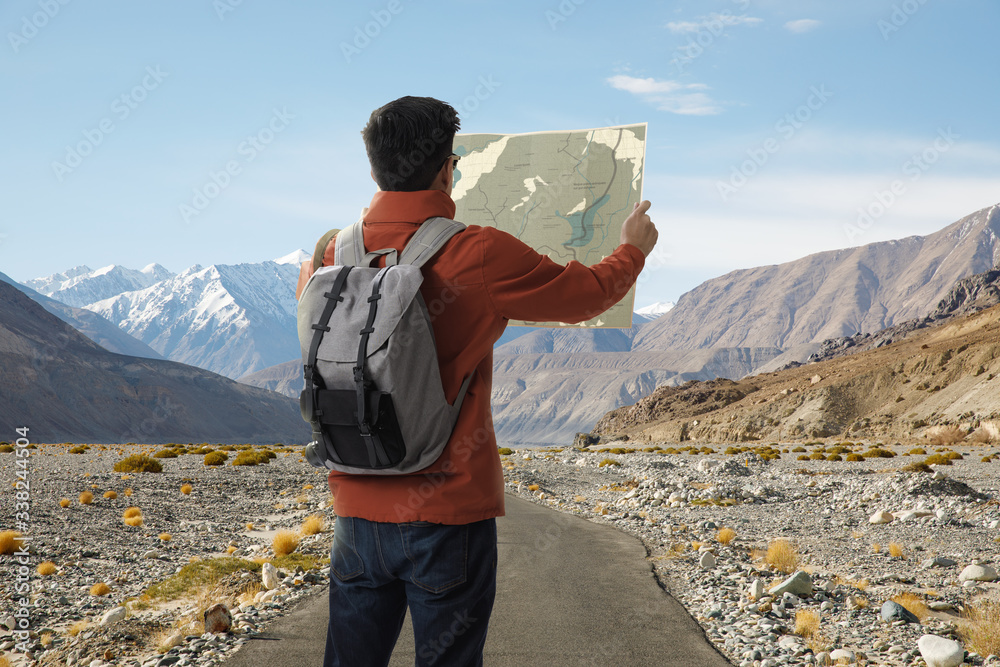 A young traveler man on the road with backpack and look searching