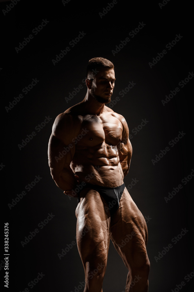 Muscular athletic bodybuilder fitness model posing. Isolated on black. Sport photo with dramatic light