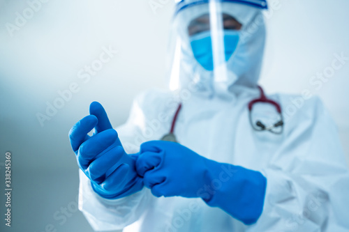 Doctor in protective hazmat PPE suit wearing medical latex gloves,New Epidemic Coronavirus,Coronavirus Disease 2019 (COVID-19),Coronavirus has turned into a global emergency.