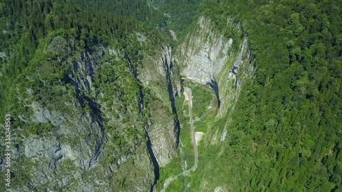 Helicopter above epic Yupshar gorge deep canyon sheer rocky cliffs Georgia Caucasus between mountains. Asphalt road serpentine traffic blue river. Cinematic natural landscape Travel tourism attraction photo