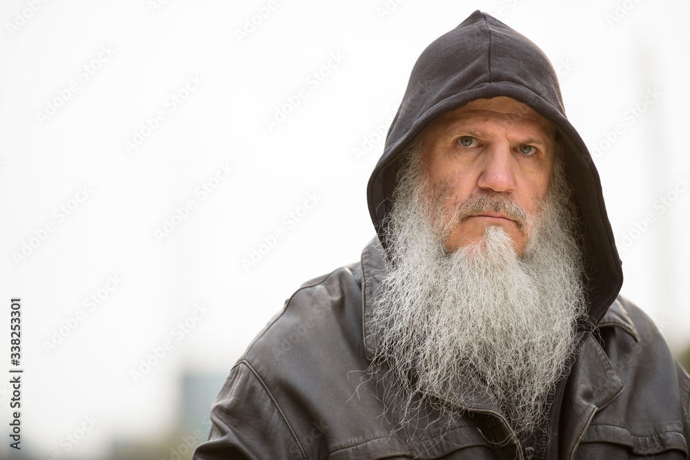 Face of serious mature bearded hipster man wearing hood Face of serious mature bearded hipster man wearing hood