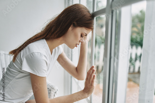 young woman looking out window