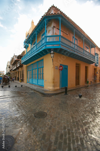 Turquoise shutters on a historic landmark building and cobblestone street in Old Havana, Cuba