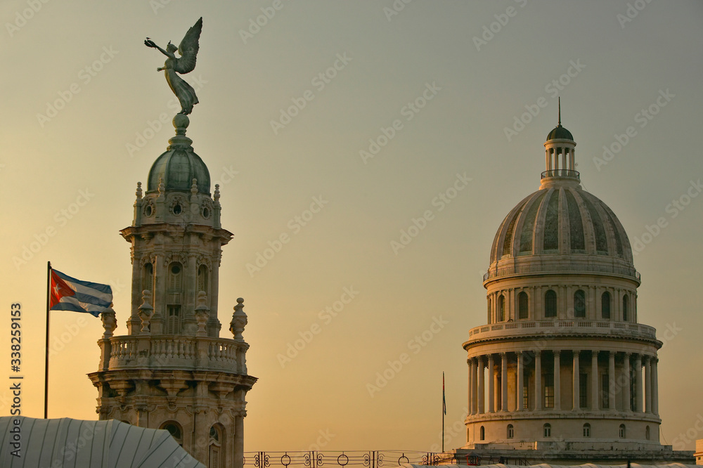 Cuban flag at sunrise with the Roofs of Opera House, Dome of the Royal Theater and Capitol, Havana