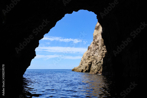 A sea cave in coastal cliffs with a view of the ocean (Orua sea cave, Coromandel Peninsula, New Zealand)