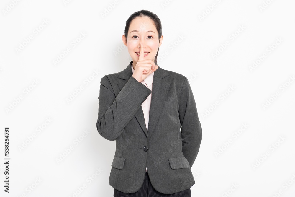 口に手を当てて内緒のポーズをする女性 口に手を当てて内緒のポーズをする女性