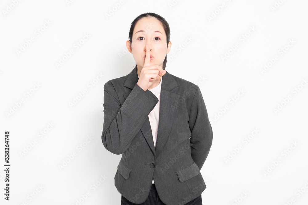 口に手を当てて内緒のポーズをする女性