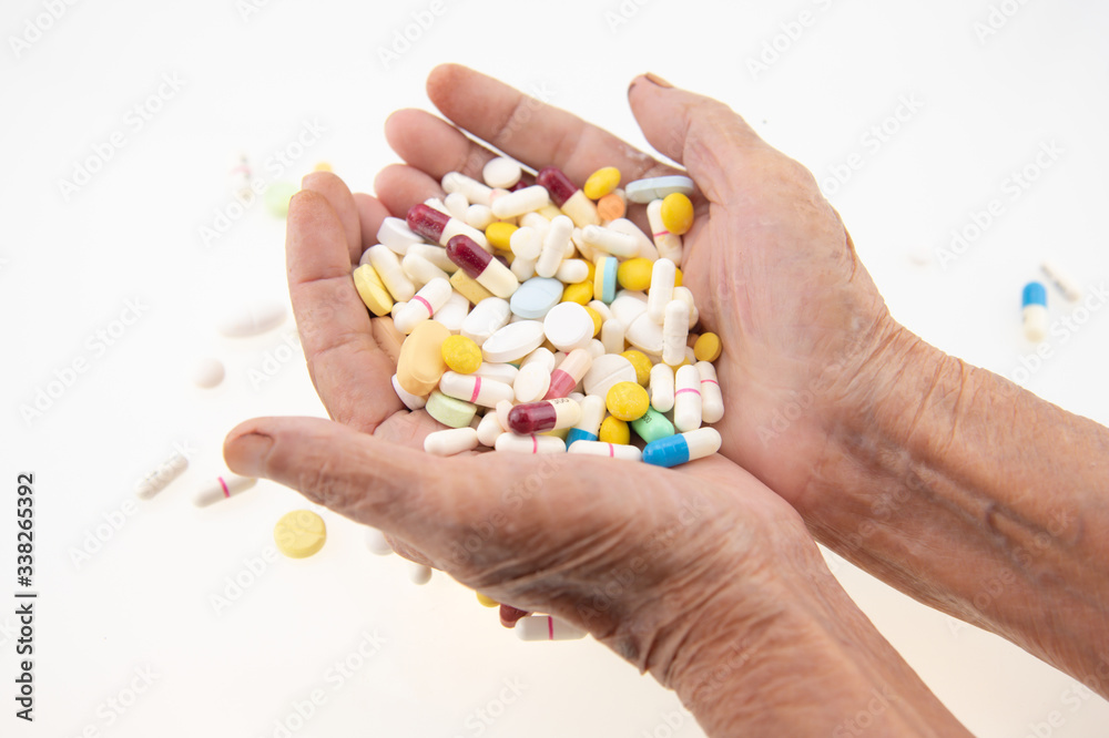 The hand of the elderly carrying a large amount of medicine