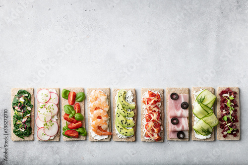 different sandwiches on a gray background. Top view, place for text.