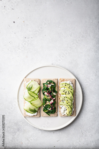 Different kinds of vegetarian sandwiches on a light background. Top view, place for text.