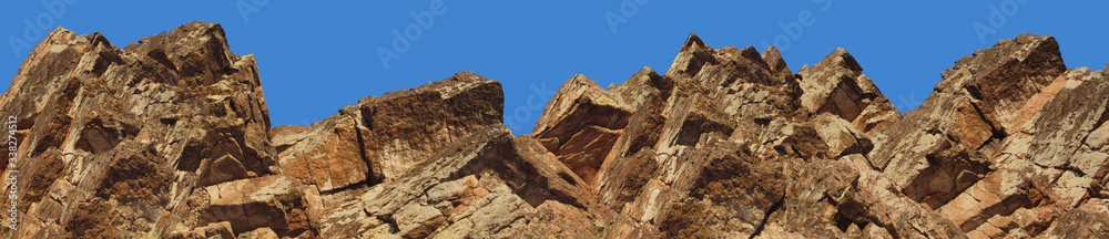 Mountain landscape. Close-up. The top of a mountain range against a clear blue sky. Panoramic. Low angle view. Wide banner with a beautiful view of the peak of the mountain range. Mountain landscape. Close-up. The top of a mountain range against a clear blue sky. Panoramic. Low angle view. Wide banner with a beautiful view of the peak of the mountain range.