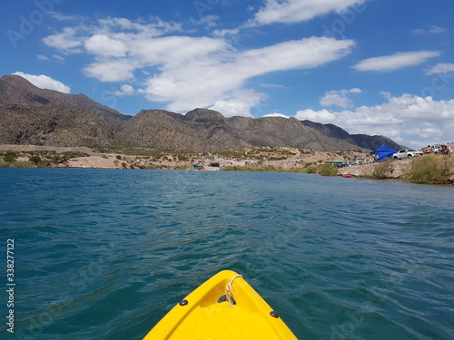 vista de un lago desde un kayak con montañas en el fondo