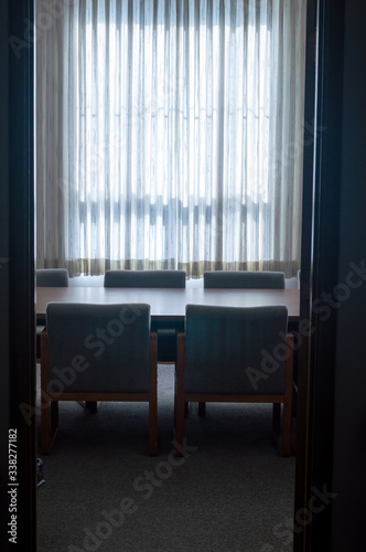 Backlit conference table and chairs through a doorway