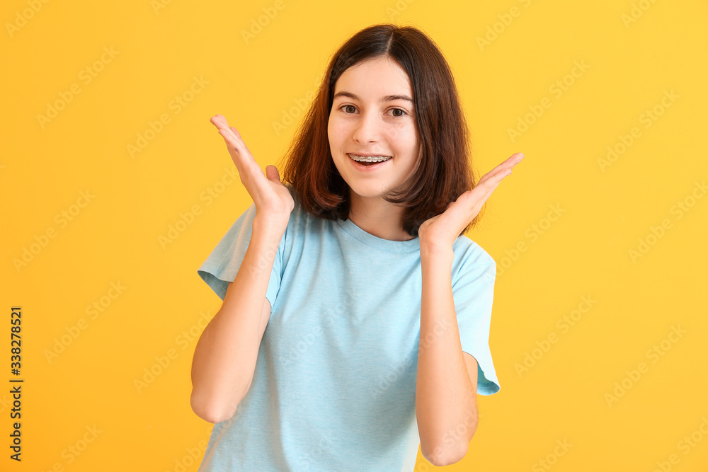 Teenage girl with dental braces on color background