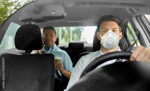 health care, safety and pandemic concept - male taxi driver driving car and passenger wearing face protective mask for protection from virus disease © Syda Productions
