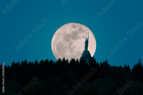 Tableau sur toile A spectacular moonrise over the Teutoburg Forest in Germany