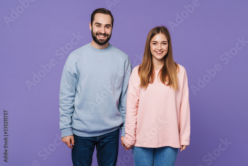 Positive loving couple isolated over purple background.