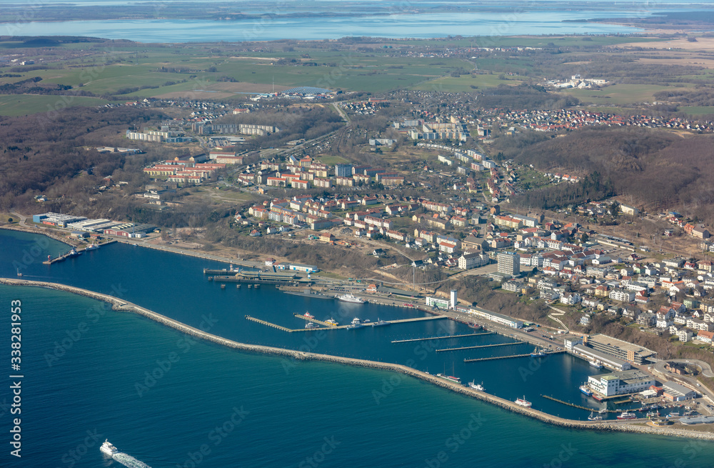 An aerial view of the city of Sassnitz on the German Baltic island of Rügen. In the front is the harbor and some ships and in the back the city and the beautiful country with a lagoon.