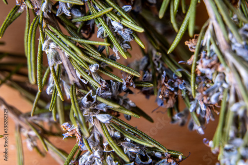 Fresh rosemary herb with flowers on wooden table. Top view rosemary macro