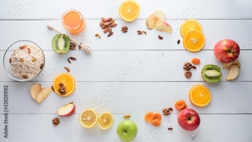 Apples, kiwi fruits, dried fruits, oranges and apples. Healthy eating concept. Shot on a white wooden table.