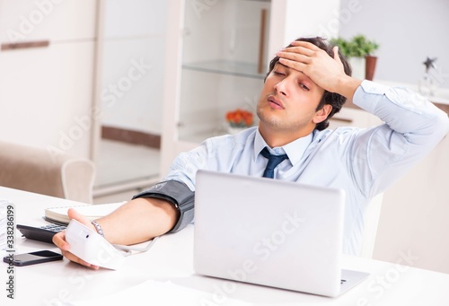 Man under stress measuring his blood pressure