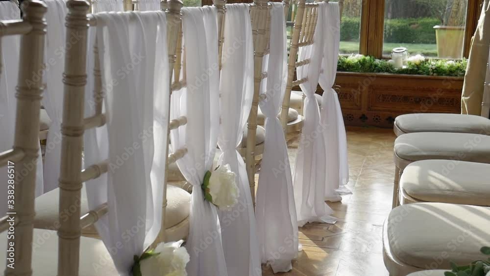 White Chairs With A Cushion Decorated With A White Cloth And A Flower For The Wedding. -close up shot White Chairs With A Cushion Decorated With A White Cloth And A Flower For The Wedding. -close up shot