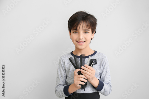 Cute little hairdresser on light background