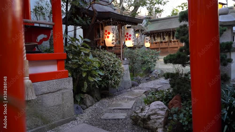 Nice View Of Small Wooden Shrine With Pretty Hanging Lanterns And Stone Path Surrounded By Lush Green Garden In Japan - Slow motion Nice View Of Small Wooden Shrine With Pretty Hanging Lanterns And Stone Path Surrounded By Lush Green Garden In Japan - Slow motion