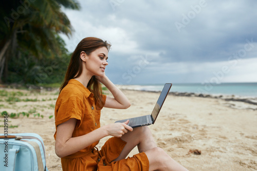 woman with laptop on the beach